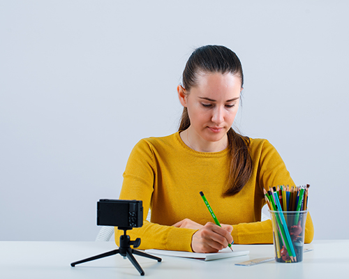 Blogger girl is writing notes on white background
